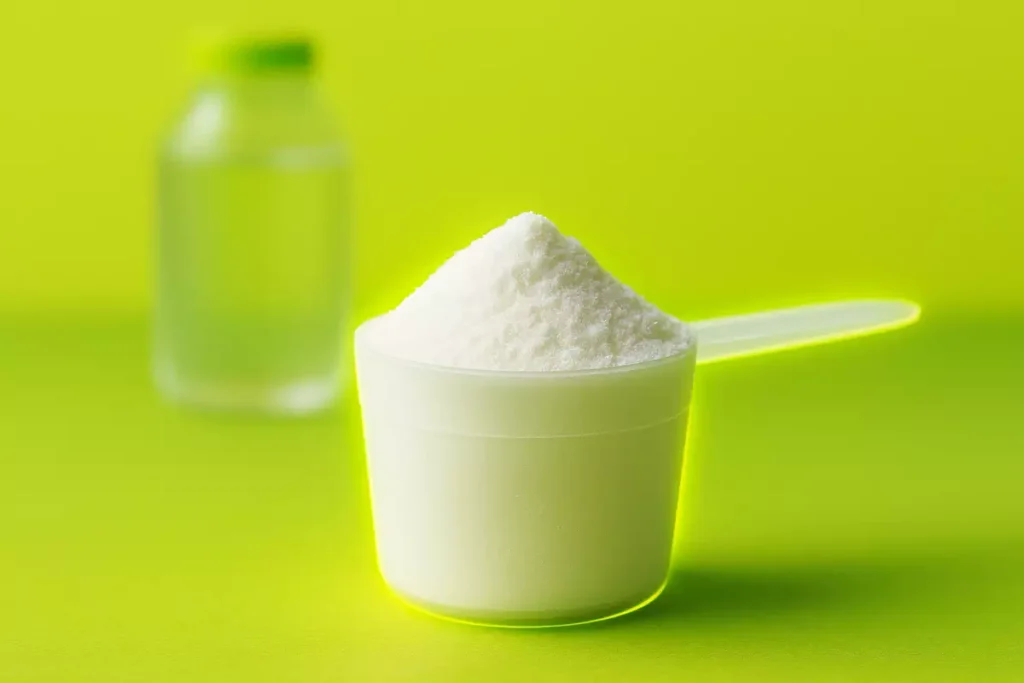 Regular creatine monohydrate scoop on gym bench with water bottle in background
