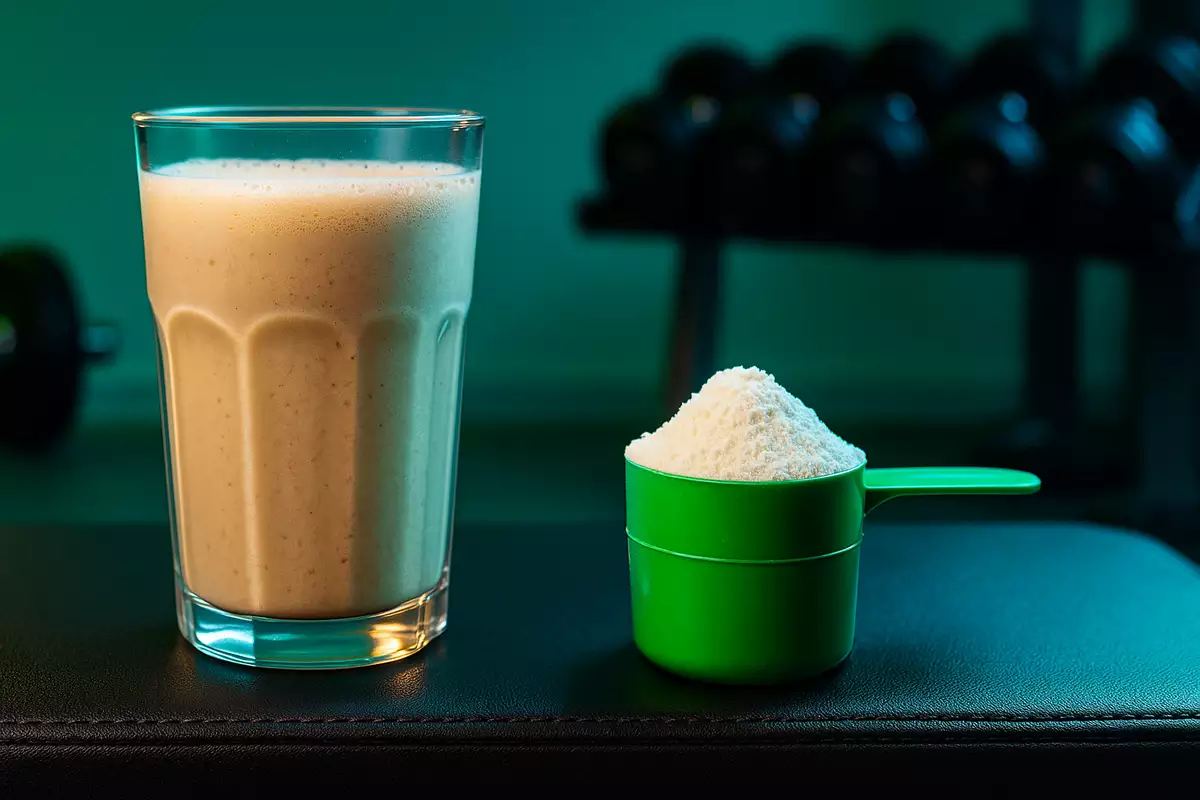 mass gainer shake and creatine powder side by side on gym bench for muscle size comparison